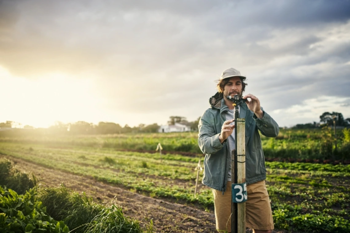 Man measuring soil at sunset