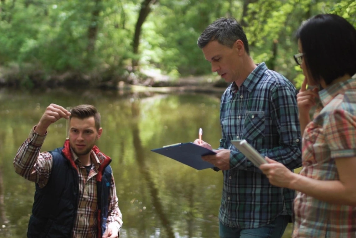 Researchers taking water samples and talking together