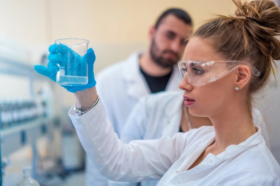 A researcher examining chemicals in a lab