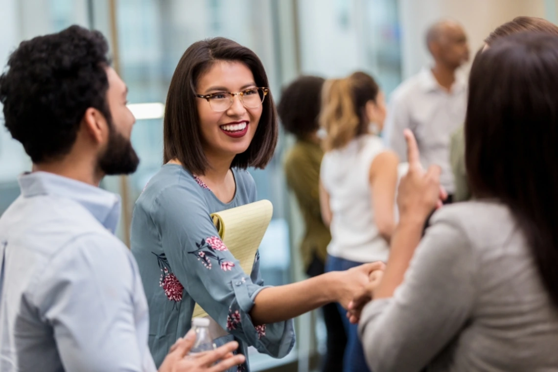 A woman shaking hands and networking with others
