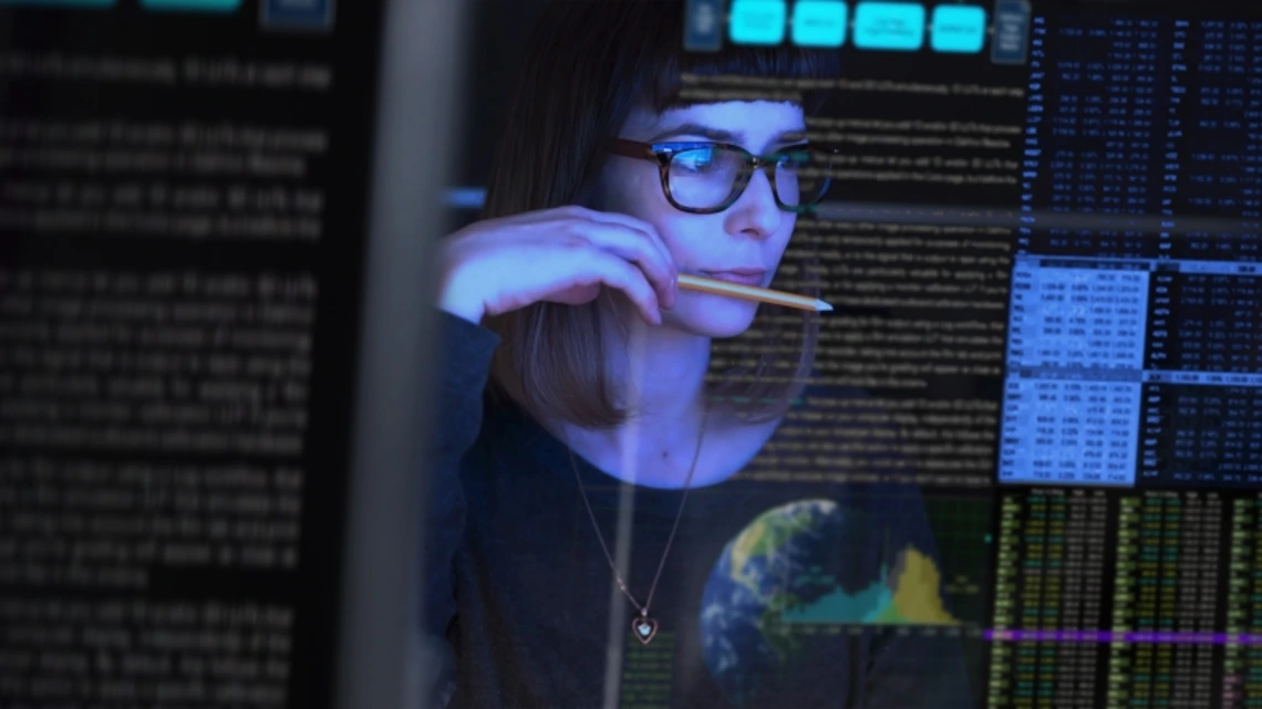 A woman examining data displayed on a computer screen