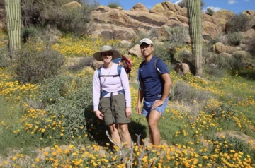 Karen Hastings, MD, PhD, pictured with her husband, Keith, in a field of wildflowers.