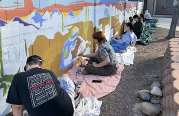 Students and Professor Kelly Leslie paint a mural at the Covenant House.