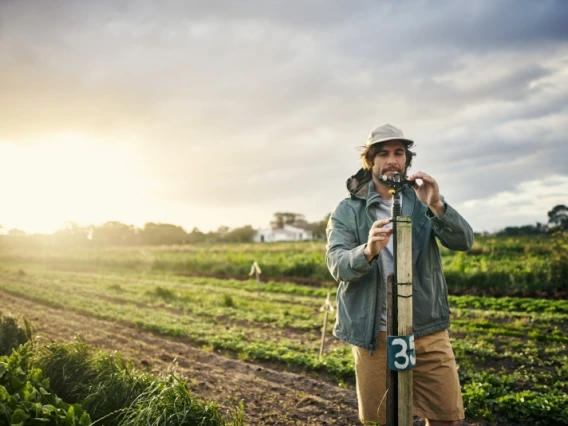 Man measuring soil at sunset