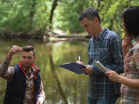 Researchers taking water samples and talking together