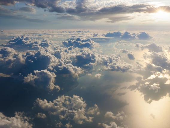 Clouds above a large body of water with sunlight reflecting off the water