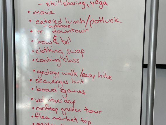 A white board with ideas written on it including topics like "Self care day", "catered lunch", and more.