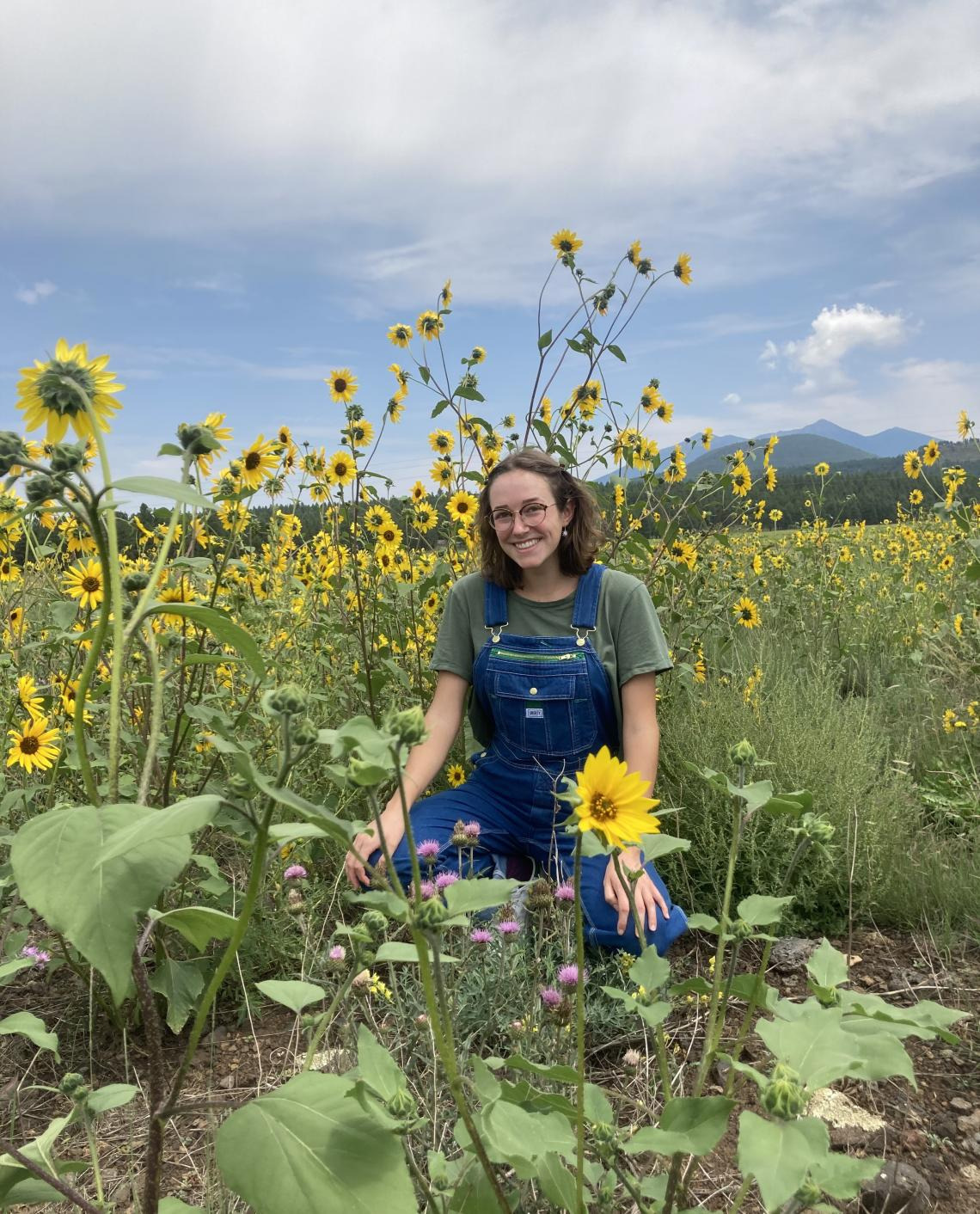 Chloe Penna outside among a field of sunflowers