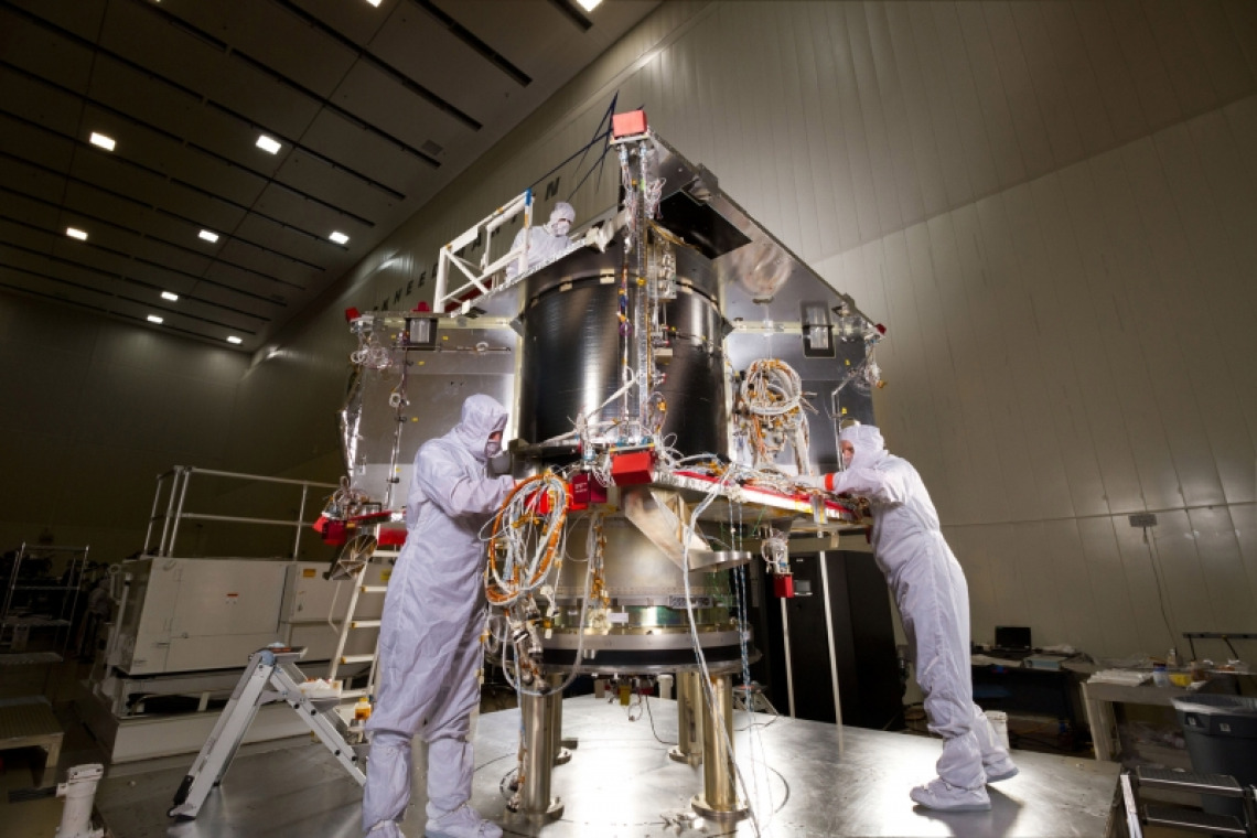 Scientists in protective gear working on a space probe