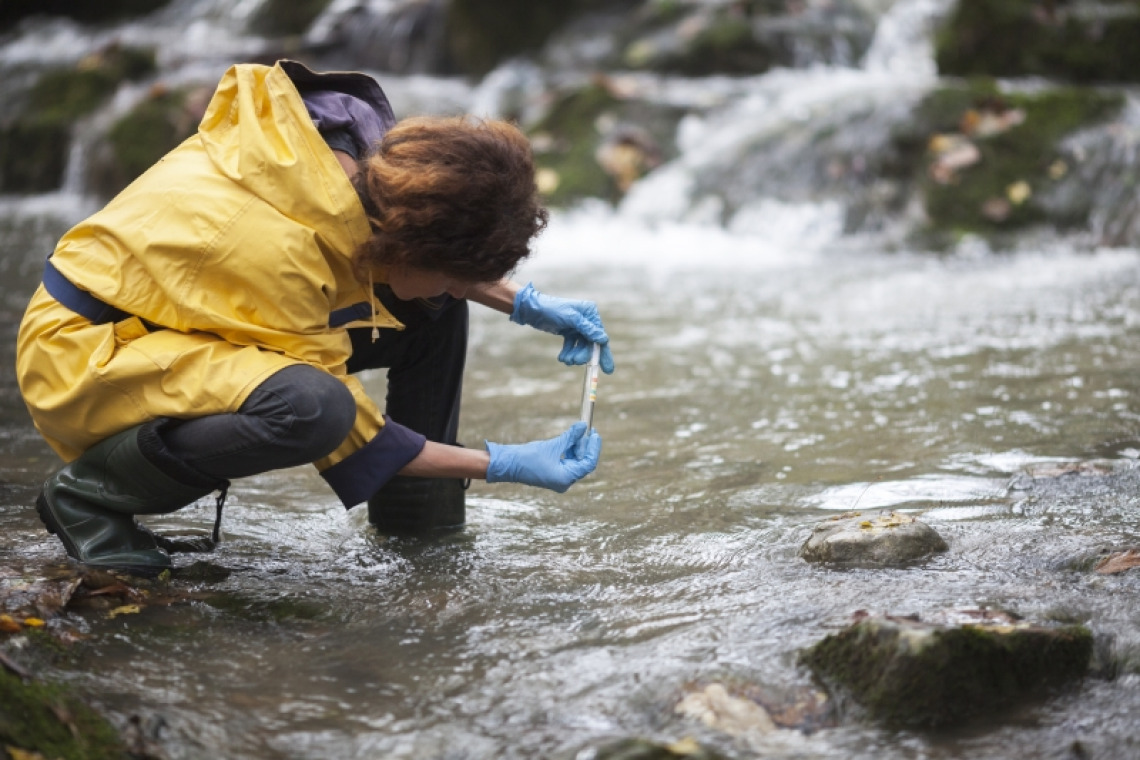 A woman taking a sample from a river