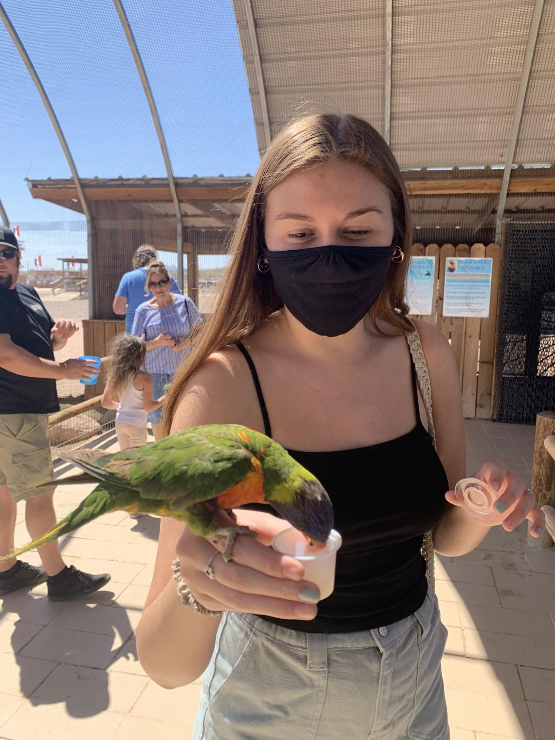 Sally Rivera holding and feeding a bird