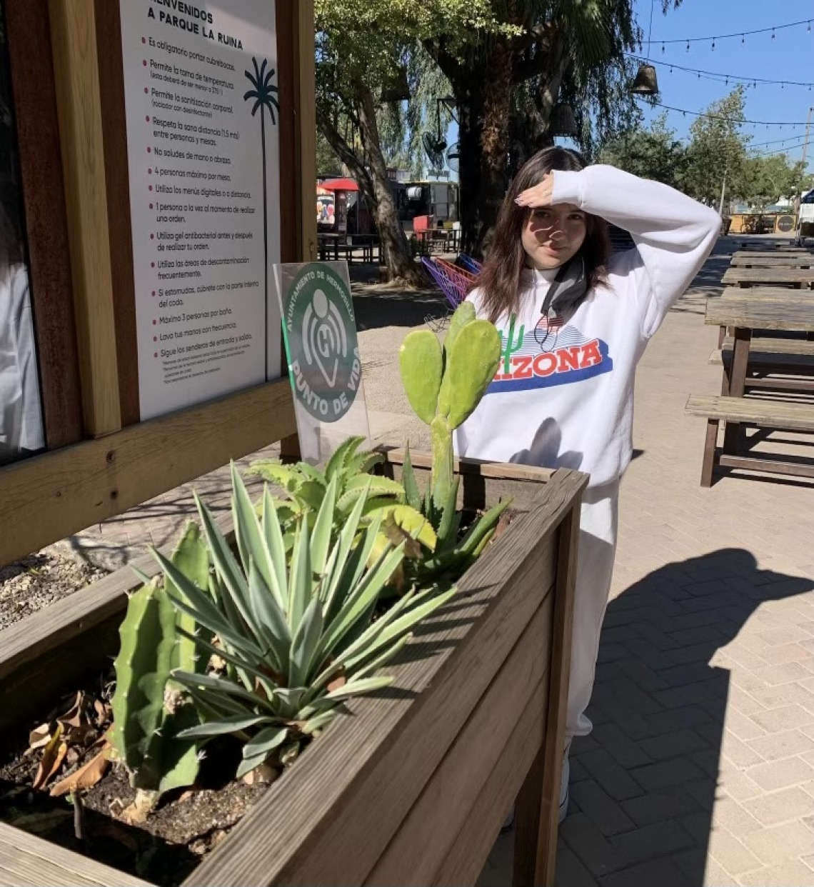 UA student Eva Quintanar standing by cacti in a planter.