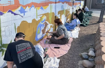 Students and Professor Kelly Leslie paint a mural at the Covenant House.