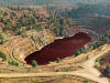 a wide view of a quarry with red acidic water at the bottom